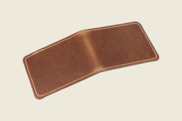 Stronghold bifold wallet in light brown Russian grain shell cordovan, open flat showing the hatch-grain exterior